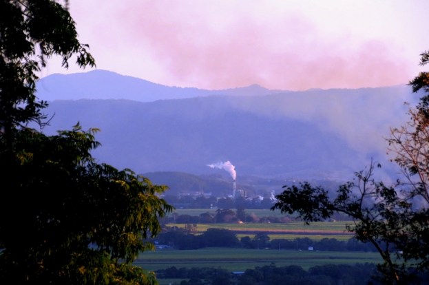 The sugar mill in the valley, surrounded by cane fields.